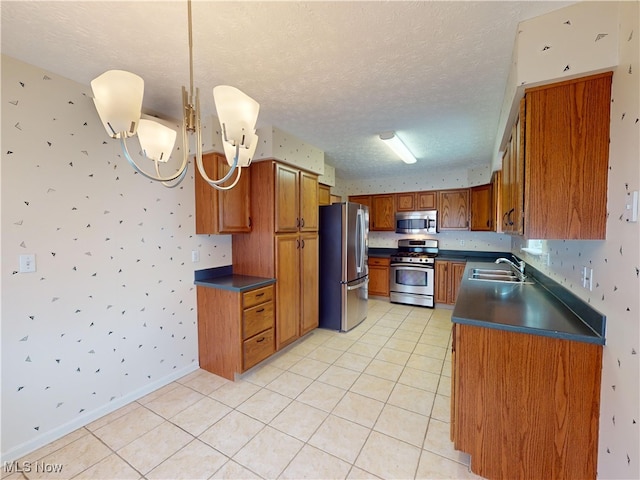 kitchen featuring stainless steel appliances, decorative light fixtures, light tile patterned flooring, a textured ceiling, and sink