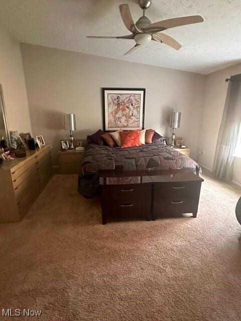 bedroom featuring ceiling fan, a textured ceiling, and carpet flooring