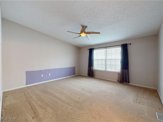 carpeted empty room featuring ceiling fan and a textured ceiling