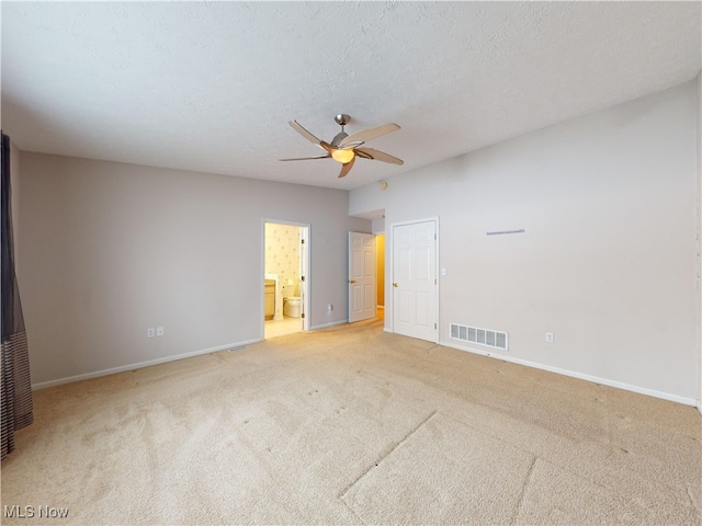 unfurnished bedroom with a textured ceiling, ceiling fan, connected bathroom, and light colored carpet