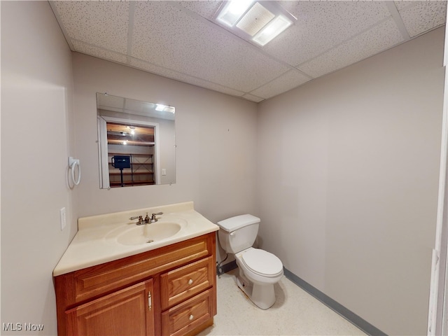 bathroom featuring toilet, vanity, and a paneled ceiling