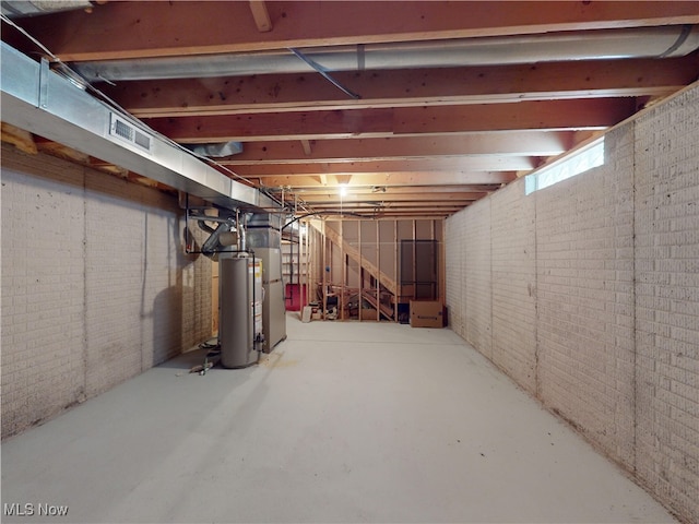 basement with brick wall and gas water heater