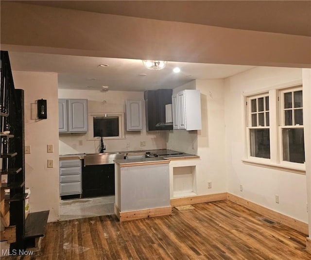 kitchen featuring hardwood / wood-style flooring, sink, gray cabinets, and kitchen peninsula