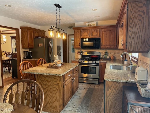 kitchen featuring a chandelier, sink, stainless steel appliances, and a center island