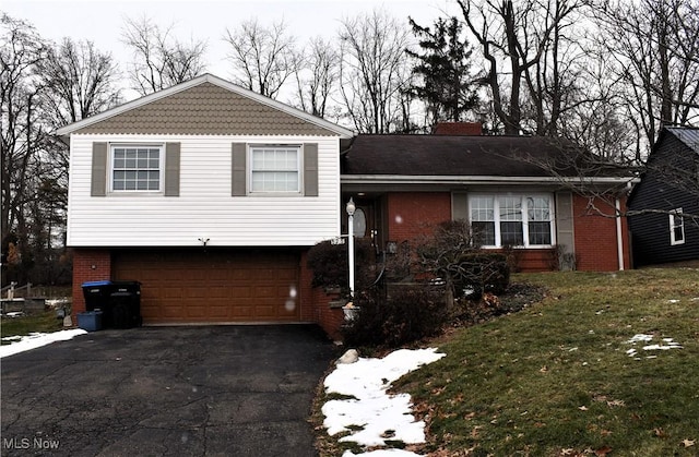 split level home featuring a front yard and a garage