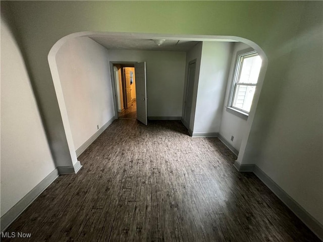 spare room with dark wood-type flooring