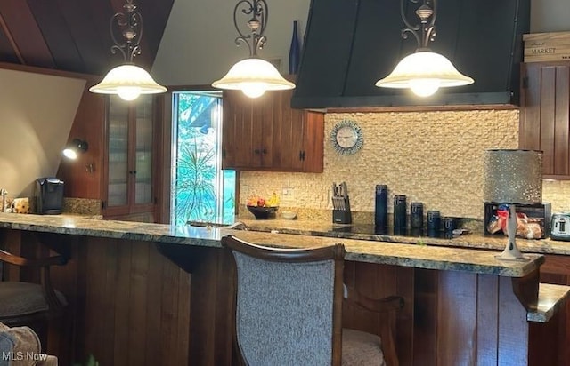 kitchen with ventilation hood, decorative backsplash, stone countertops, and pendant lighting