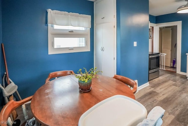 dining space with wood-type flooring