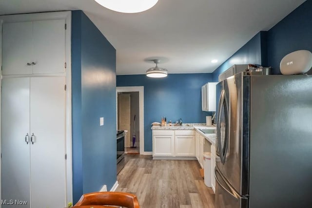 kitchen featuring white cabinets, appliances with stainless steel finishes, and light hardwood / wood-style floors