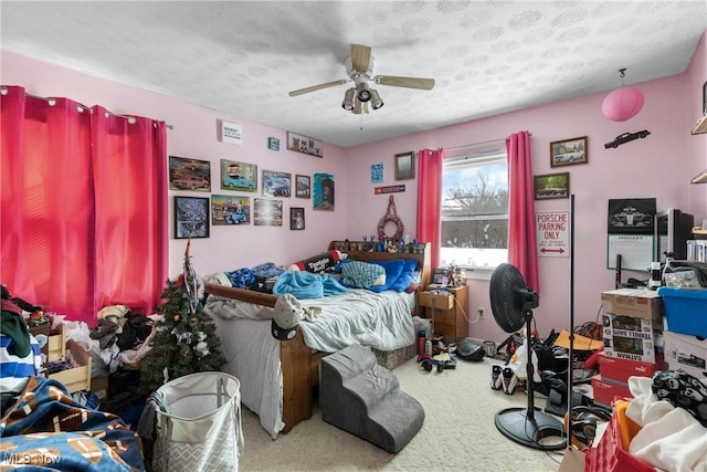 bedroom with a textured ceiling, ceiling fan, and carpet flooring