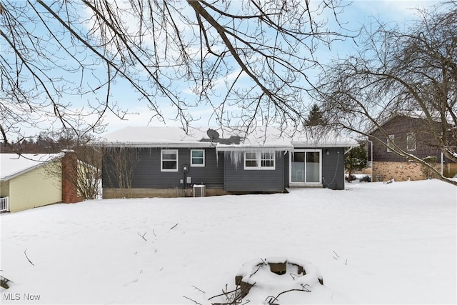 snow covered house with central air condition unit