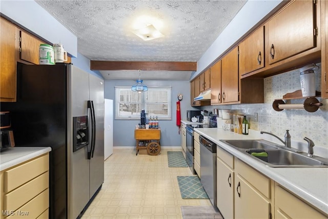 kitchen with a textured ceiling, stainless steel appliances, sink, backsplash, and beam ceiling