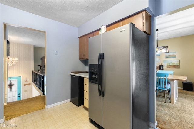 kitchen featuring decorative light fixtures, light colored carpet, an inviting chandelier, a textured ceiling, and stainless steel fridge