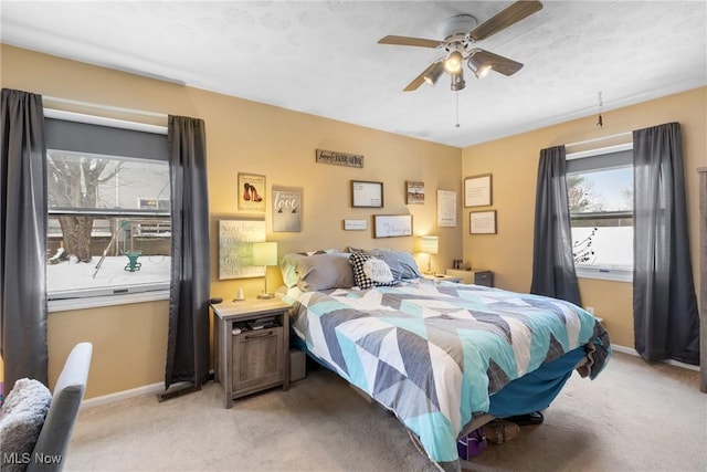 bedroom featuring light carpet, ceiling fan, and a textured ceiling