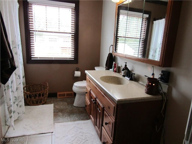 bathroom with toilet, tile patterned flooring, and vanity