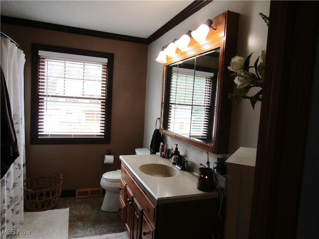 bathroom with toilet, vanity, and ornamental molding