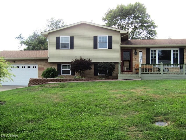 tri-level home featuring a garage and a front lawn