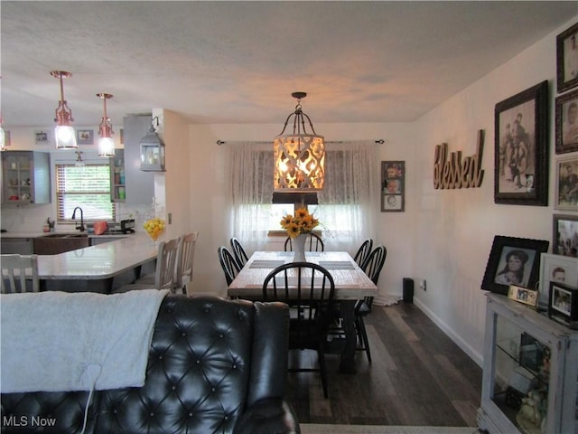 dining space with sink, dark hardwood / wood-style flooring, and a chandelier