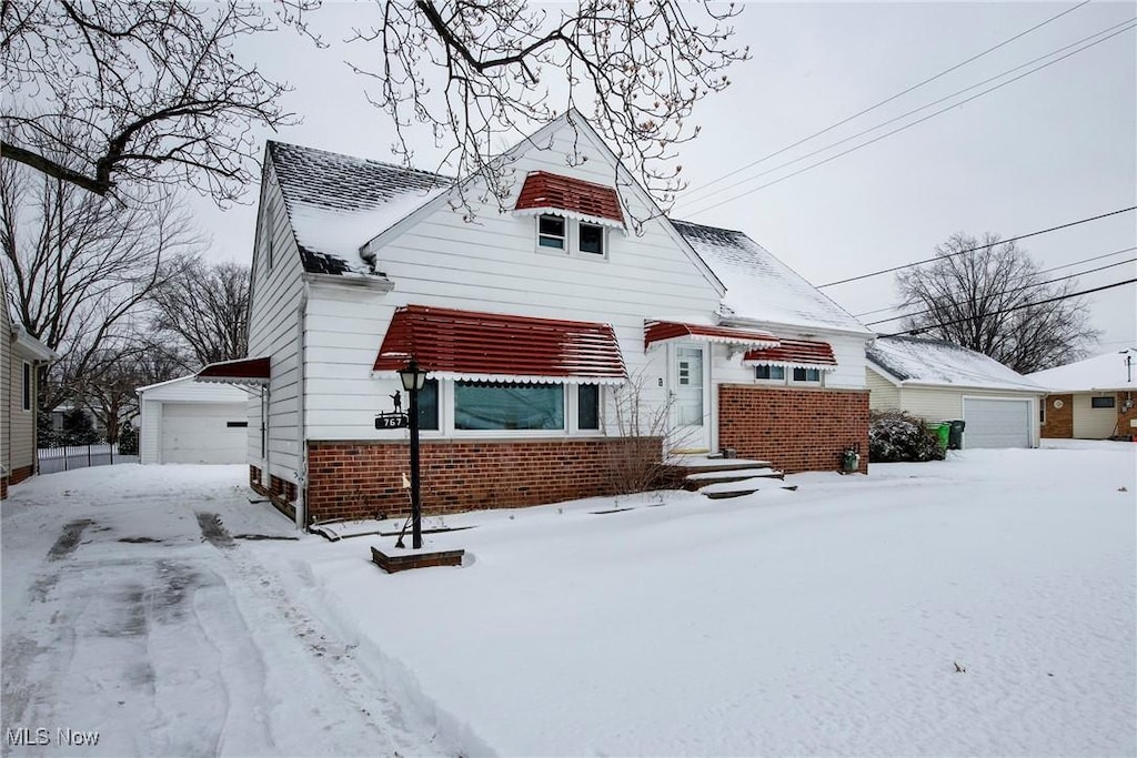 view of front of property with a garage and an outbuilding