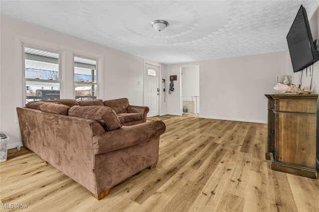 living room featuring light wood-type flooring and a textured ceiling