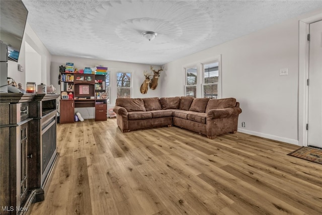 living room featuring light wood-type flooring and a textured ceiling