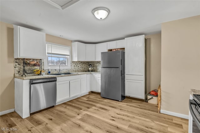 kitchen with white cabinetry, stainless steel appliances, decorative backsplash, light wood-type flooring, and sink