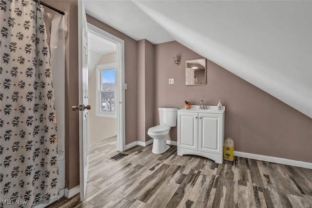 bathroom featuring toilet, vanity, vaulted ceiling, and hardwood / wood-style floors