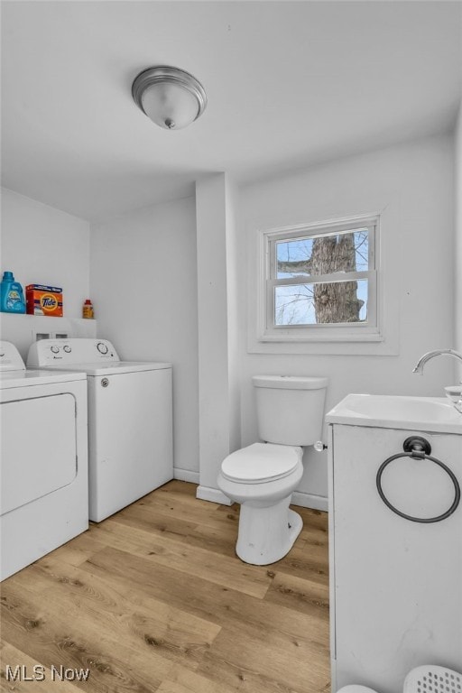 bathroom with toilet, vanity, independent washer and dryer, and hardwood / wood-style flooring