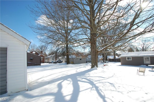 snowy yard with an outbuilding