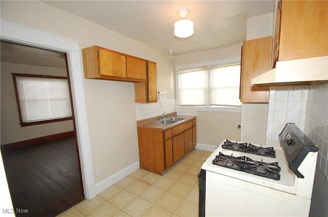 kitchen featuring white range with gas cooktop, decorative backsplash, and sink