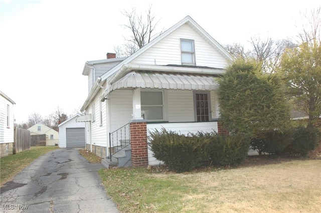 view of front facade featuring an outbuilding, a garage, and a front lawn