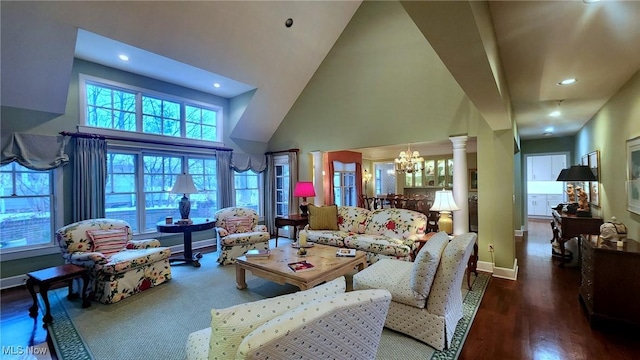 living area with wood finished floors, a high ceiling, decorative columns, recessed lighting, and a notable chandelier