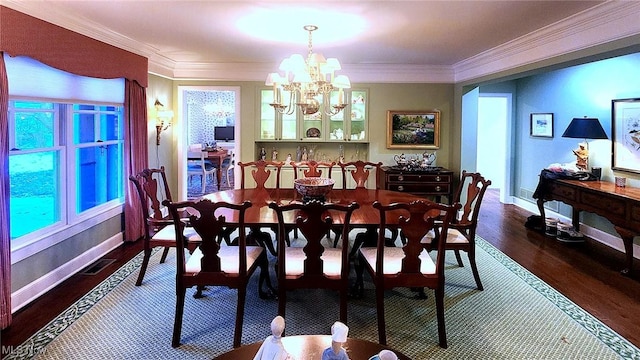 dining area with crown molding, an inviting chandelier, and dark hardwood / wood-style flooring