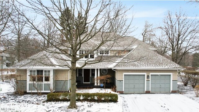 view of front of house with an attached garage and roof with shingles