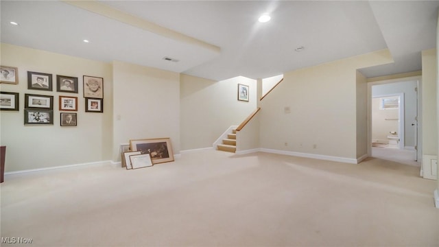 finished below grade area featuring visible vents, stairs, baseboards, and carpet floors