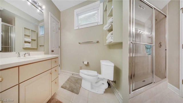 bathroom with tile patterned floors, toilet, a shower stall, baseboards, and vanity