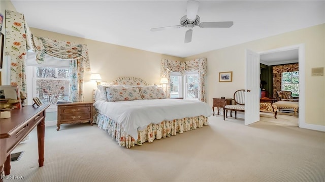 bedroom with multiple windows, light colored carpet, and ceiling fan