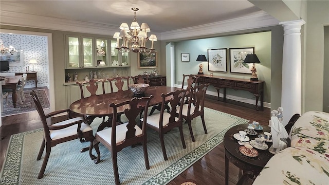 dining room with ornamental molding, dark wood-style floors, decorative columns, baseboards, and a chandelier