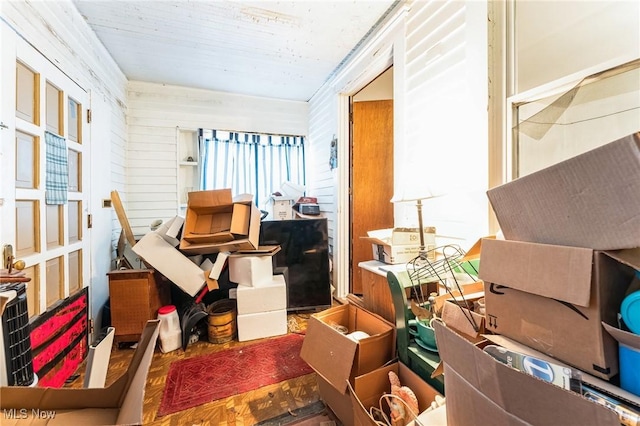 misc room with dark parquet floors and wooden walls