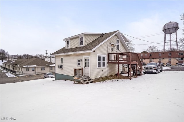 snow covered house with a wooden deck