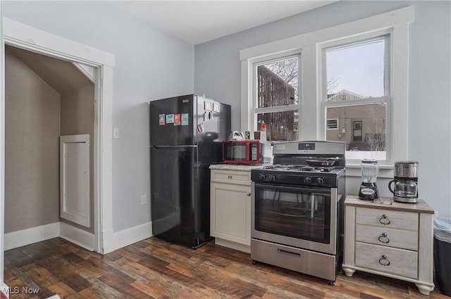 kitchen featuring black fridge, gas stove, and dark hardwood / wood-style floors