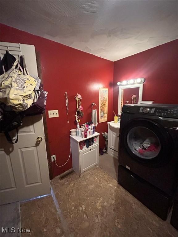 clothes washing area with washer / dryer