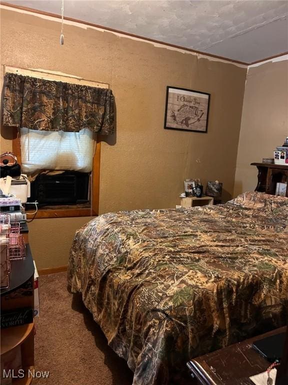 carpeted bedroom with a textured ceiling and crown molding