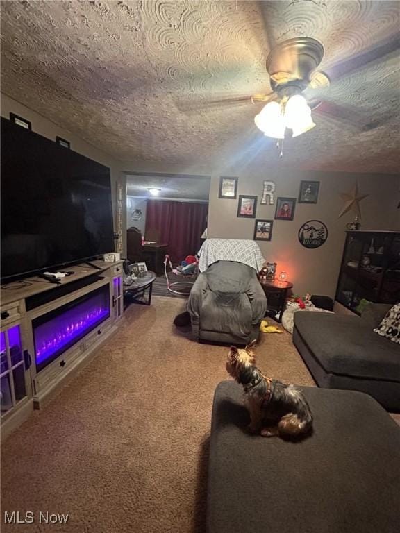 living room featuring ceiling fan, a textured ceiling, and carpet