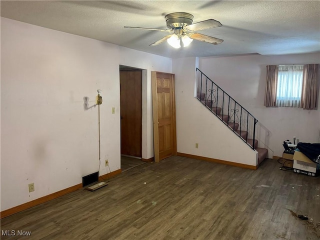 interior space with ceiling fan, a textured ceiling, and dark hardwood / wood-style floors