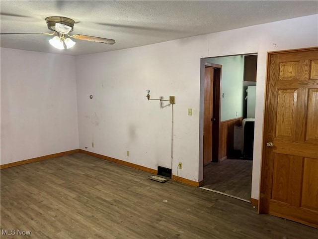 unfurnished room featuring ceiling fan, dark wood-type flooring, and a textured ceiling