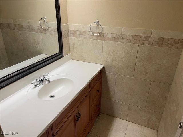 bathroom with tile patterned flooring, tile walls, and vanity