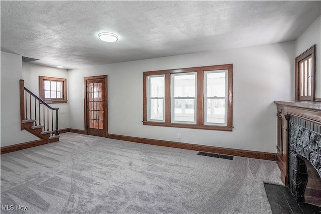 unfurnished living room with a textured ceiling and carpet