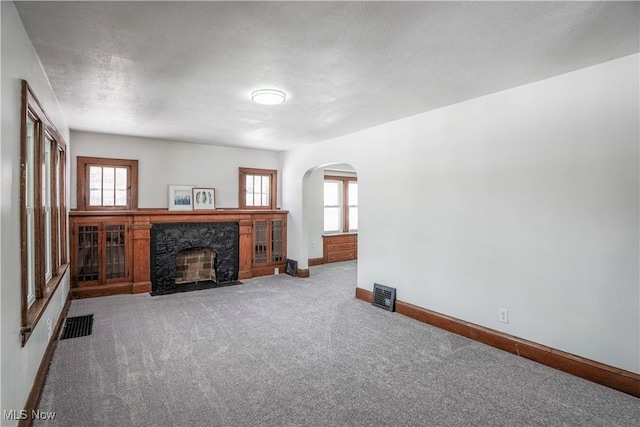 unfurnished living room featuring light carpet and a fireplace