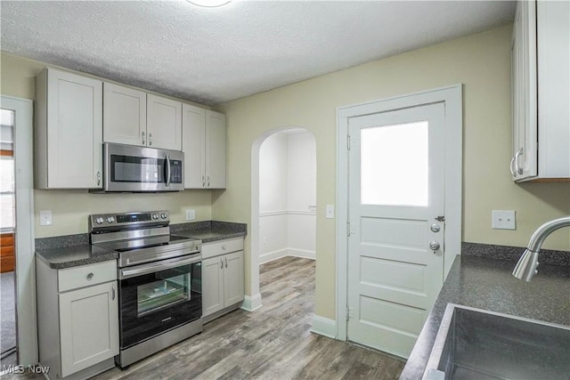 kitchen featuring white cabinets, appliances with stainless steel finishes, sink, and a textured ceiling